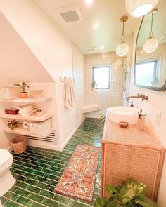 a bathroom with green tile flooring and white walls, along with a pink sink