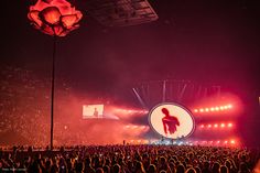 the stage is lit up with red lights and people are standing in front of it