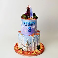 a three tiered cake decorated with frozen princess characters