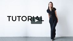 a woman standing in front of a white wall with the word tutor written on it