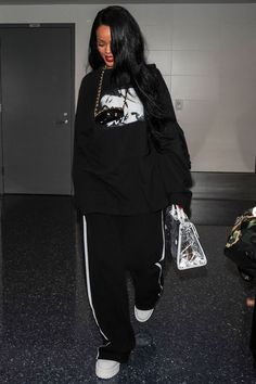 a woman with long black hair is walking through an airport