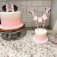 two cakes decorated with pink and white frosting