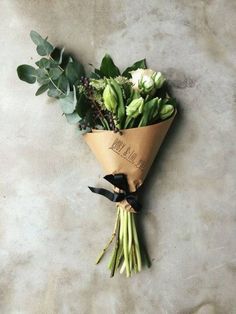 a bouquet of flowers is wrapped in brown paper