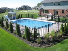 an above ground swimming pool surrounded by landscaping