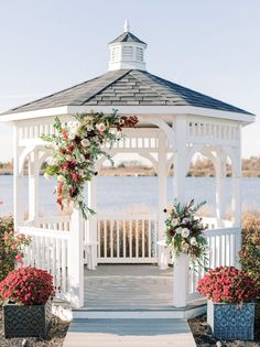 a white gazebo with flowers and greenery on it