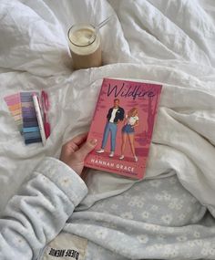 a person laying in bed holding a book