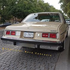 a tan car parked on the side of a road