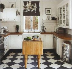 a kitchen with black and white checkered flooring, chandelier above the stove