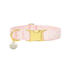 a pink collar with yellow flowers on it and a gold plated name tag attached to the collar