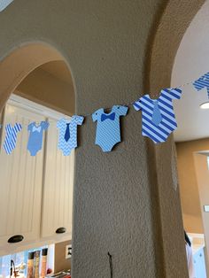 blue and white baby onesuits are hanging on the wall in this kitchen area