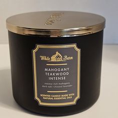 a candle that is sitting on a white counter top with the label mahogany teakwood intense