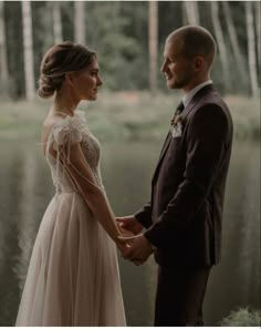 a man and woman standing next to each other holding hands