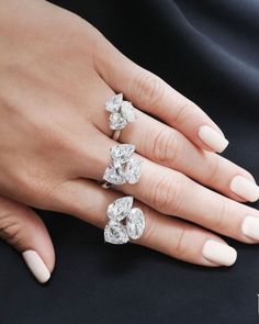 a woman's hand with three diamond rings on her left and the middle finger