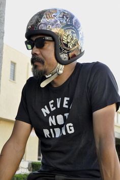 a man wearing a motorcycle helmet and sunglasses on his bike with the words never not riding printed on it