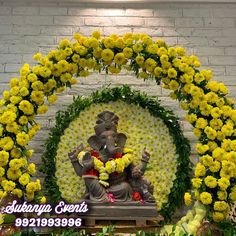 an elephant statue surrounded by yellow flowers and greenery