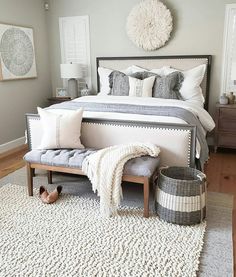 a bedroom with a bed, rugs and two baskets on the floor in front of it