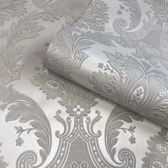 a silver and white wallpaper with an intricate design on it's surface,