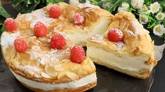 a cake with raspberries and powdered sugar on top sits on a plate