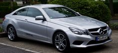 a silver mercedes cla parked in front of some bushes