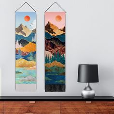 two wall hangings with mountains in the background