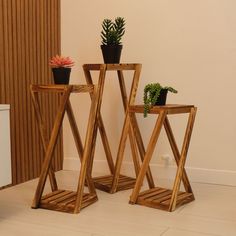 two wooden plant stands sitting next to each other