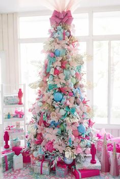 a pink and blue christmas tree decorated with bows