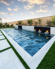 an outdoor swimming pool with artificial grass around it and two people in the water at the end