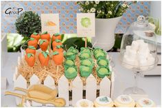 an assortment of desserts on display at a baby's first birthday party, including carrots and marshmallows