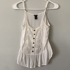 Like New! Beautiful Lace Detailing And Cute Buttons Dress Up This White Spaghetti Strap Tank Top From Forever 21. The Back Is Cropped, Whereas The Front Is Not, Giving This Top A Low-High Silhouette White Tops With Adjustable Straps For Day Out, Trendy White Camisole For Day Out, White Trendy Camisole For The Beach, White Trendy Camisole For Summer, Trendy White Camisole For The Beach, Trendy White Camisole For Beach, Trendy White Camisole For Summer, White Trendy Summer Camisole, Trendy White Summer Camisole