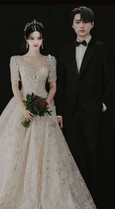 a man and woman in formal wear standing next to each other wearing tuxedos