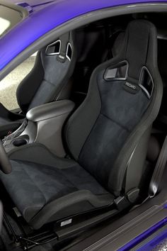 the interior of a blue car with black seats