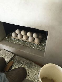 eggs are sitting in an oven on the floor next to a person's feet