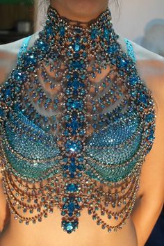 a woman wearing a blue and green beaded halter top with beads on it