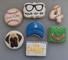 decorated cookies are arranged in the shape of baseballs, hats, and other sports related items