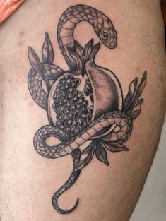 a black and white photo of a snake on the thigh with an apple in it