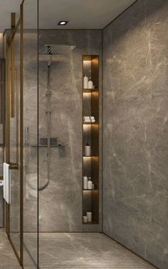 a bathroom with a walk in shower next to a white toilet and wooden shelves on the wall