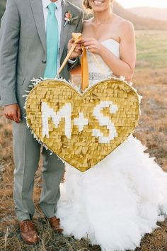 a bride and groom holding up a heart shaped sign with the number twenty five on it