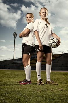 two female soccer players are posing for a photo