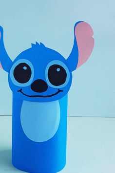 a blue paper cup with a cartoon character on it's face and ears, sitting in front of a white background