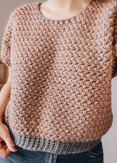 a close up of a person wearing a sweater with crochet on the back