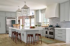 a kitchen with an island and stools next to the stove top oven in it