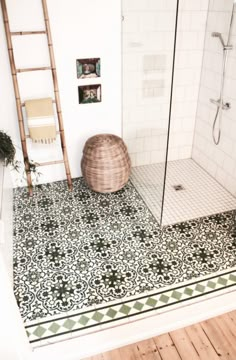 a bathroom with a tiled floor, shower and wooden ladder in the corner on the wall