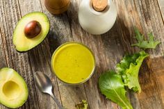 an avocado and some other foods on a table with utensils next to it