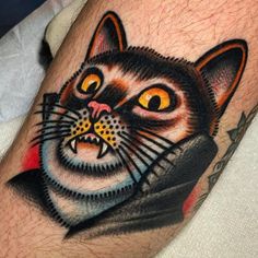 a black cat with yellow eyes and an angry look on its face is shown in this tattoo design