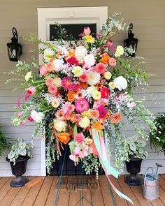 a bunch of flowers that are on top of a wooden floor in front of a door