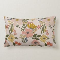 a pink and yellow floral pillow on a white wall