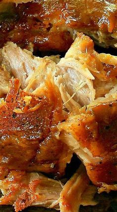 closeup of meat with sauce on it sitting on a black tablecloth covered plate