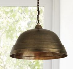 a light fixture hanging from a ceiling in front of a window