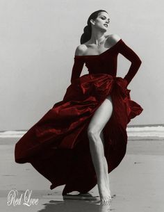 black and white photograph of woman in dress on beach