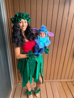 a woman holding a baby dressed up as tinkerbell and peter the neverland elf